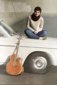 picture of a girl with her belongings sitting on her car ready to leave