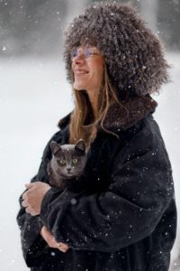 Woman holding her furbaby in her coat