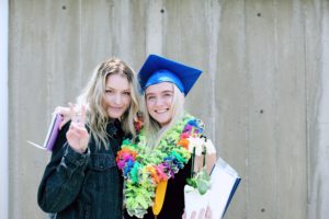 Two girls in high school graduation cap and gown.