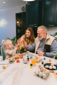 grandfather, daughter and granddaughter painting eggs