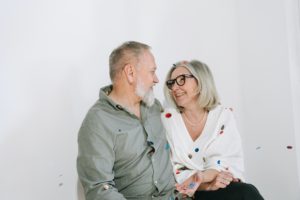 happy empty nesters sitting together smiling at eachother